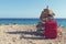 Red suitcase and pile of stones on a sea shore at Cap de ses Salines Majorca