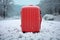 A red suitcase sitting in the snow, AI