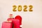Red suitcases, Santa Claus hat and gift boxes. Helium balloons with the numbers 2022.