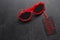 Red sunglasses. Black Friday - handwritten inscription on the tag. The concept of holiday sales. Dark concrete background. Copy