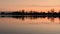 Red sunset over the water of a village lake