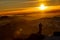 Red sunset and the silhoute of  photographer enthusiast stay on cliff and thinking