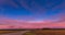 Red sunset sky time lapse with a road. Clouds timelapse nature background. Dramatic evening color beauty. Twilight, dusk