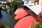 Red sunshade umbrellas along the romantic canal ,little Venice, the course of the Lauch in Colmar.