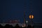 Red super flower Moon rise in the Irish sky between iconic Poolbeg Generating Station Poolbeg CCGT chimneys on May 26, 2021