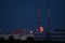 Red super flower Moon rise in the Irish sky between iconic Poolbeg Generating Station Poolbeg CCGT chimneys on May 26, 2021