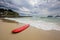 Red surfboard laying on shorebreak