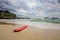 Red surfboard laying on shorebreak