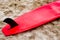 Red surfboard on sand