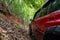 Red suv summer car and road in mountains Driving in forest dirt road Free space for your decoration Green forest background