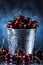 Red sweet cherries close up in a metal bucket on a dark and blue background. Summer taste.