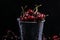 Red sweet cherries in a metal bucket on black background. Summer taste. Fresh berries