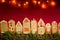 Red table cloth with town of cute gingerbread houses decorated with icing.