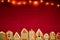 Red table cloth with town of cute gingerbread houses decorated with icing