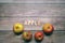Red tasty apples fruits on a wooden table with apple word written on wood