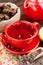 Red tea cup and teapot, healing herbs and lemon