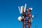 Red telecommunication tower with 4G, 5G transmitters. Cellular base station with transmitter antennas on a telecommunication tower