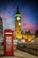 Red telephone booth in front of the illuminated Big Ben clocktower in London
