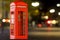 Red telephone box on the night street blurred background. 3D rendering