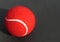 Red Tennis Ball with white curve line on dark grey background