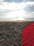 a red tent set up on a stretch of sand on the beach in the afternoon, camping activities to fill vacation time