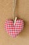 Red textile heart over brown craft recycle cork board background. Valentine`s day concept.
