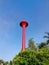 Red thai water tower tank with blue sky. Vertical photo