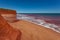 Red tide and waves against Pindan Cliffs at James Price Point