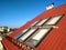 Red tiled house roof with attic windows. Roofing construction, window installation, modern architecture concept