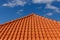 Red tiles panels roof under blue sky