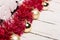 Red tinsel, white foam snowflakes and golden balls on a wooden table