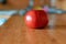 Red tomato on a brown wooden table. A round vegetable is placed singly in the kitchen