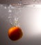 Red tomato drops in water with a spray
