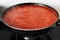 Red tomato sauce cooking on fire in pan