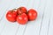 Red tomatoes on a branch on a wooden table