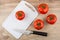 Red tomatoes, cutting board and kitchen knife on table