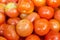 Red tomatoes display at fresh market stall background.