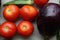 Red tomatoes display with multiple vegetables for health and diet background.