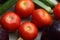 Red tomatoes display with multiple vegetables for health and diet background.