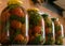 Red tomatoes and green spices in glass jars, canned vegetables, tomato pickling, winter products, healthy diet, vegetarian diet,