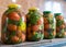 Red tomatoes and green spices in glass jars, canned vegetables, tomato pickling, winter products, healthy diet, vegetarian diet,