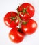 Red tomatoes on a green twig on white background