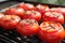 red tomatoes on a grill, close-up, featuring heat waves