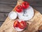 Red tomatoes on a wooden saw stand, kitchen board with decor. Coarse salt, scattering of peppers. View from above.