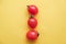 Red tomatos vegetable on a yellow background. Top view. Minimalist Style. Copy, empty space for text