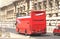 Red tourist bus without roof with tourists traveling through streets