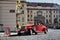 Red touristic oldtimer from the beginning of the 20th century on the historic cobbled road in Prague