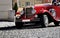 Red touristic oldtimer from the beginning of the 20th century on the historic cobbled road in Prague