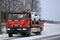 Red Tow Truck Tows a Breakdown Car in Winter