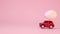 Red toy car with a golden egg on the hood on a pink background. Gift delivery. Happy easter concept